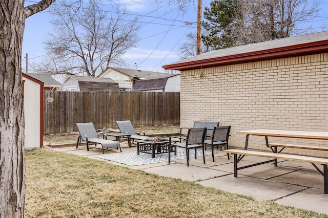 view of patio with a fire pit, an outdoor structure, and fence