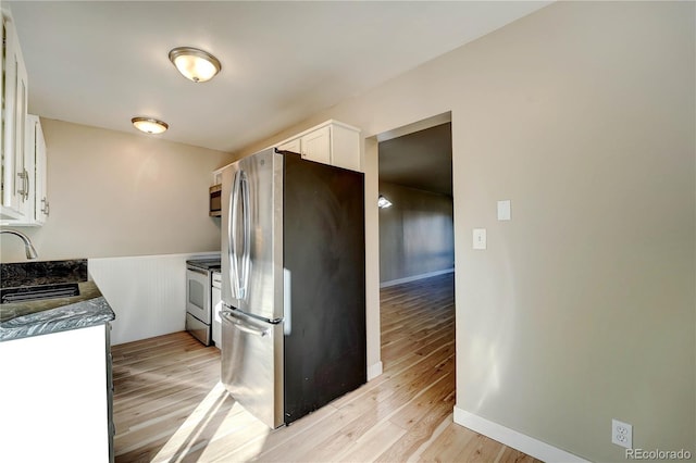 kitchen featuring white cabinets, appliances with stainless steel finishes, light wood-type flooring, and sink