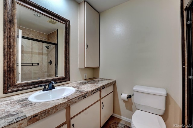 bathroom featuring toilet, vanity, and walk in shower