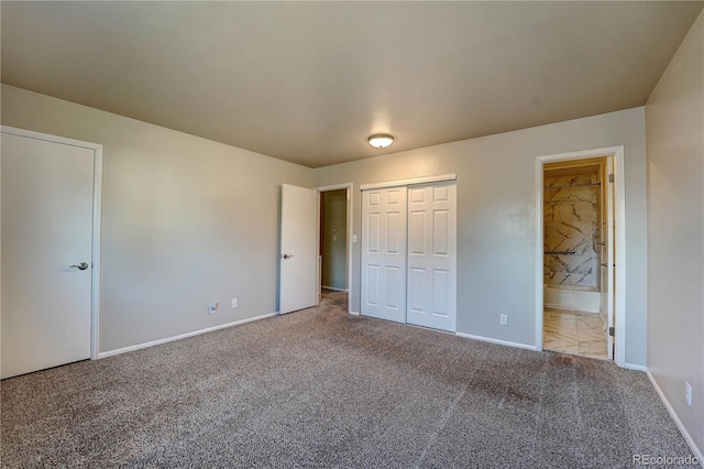 unfurnished bedroom with ensuite bathroom, light colored carpet, and a closet