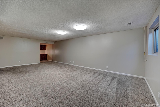 empty room with carpet and a textured ceiling