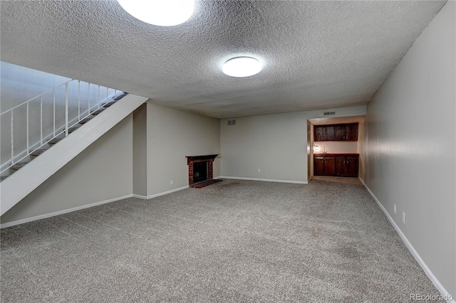 basement featuring carpet flooring, a fireplace, and a textured ceiling