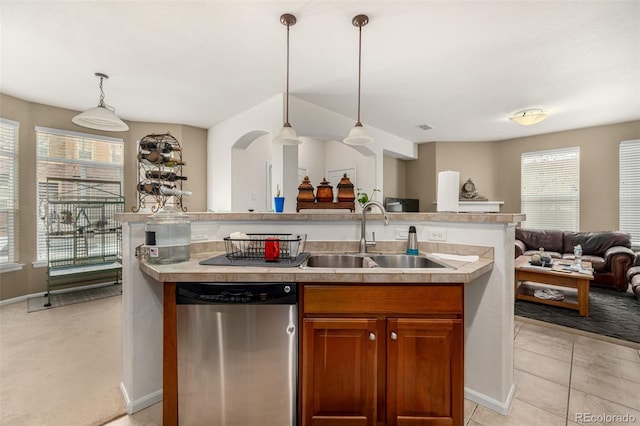 kitchen with open floor plan, light countertops, stainless steel dishwasher, and a sink