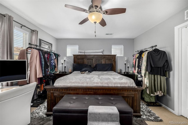 bedroom featuring light carpet, ceiling fan, multiple windows, and visible vents