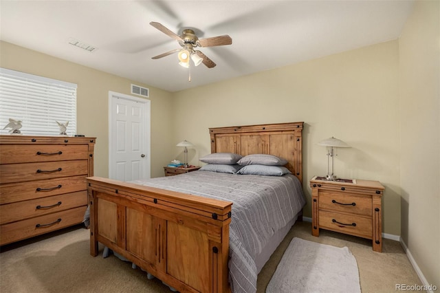 bedroom featuring baseboards, a ceiling fan, visible vents, and light colored carpet