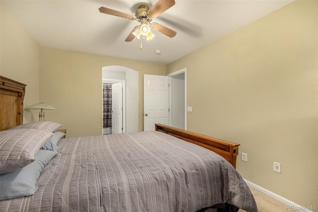 bedroom featuring arched walkways, carpet floors, a ceiling fan, and baseboards