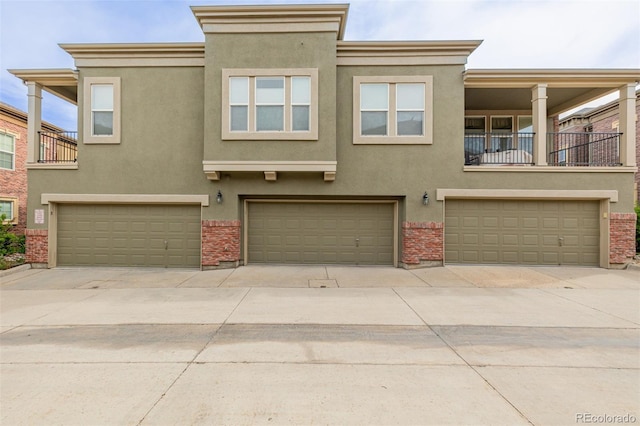 view of front of house with an attached garage, stucco siding, and concrete driveway