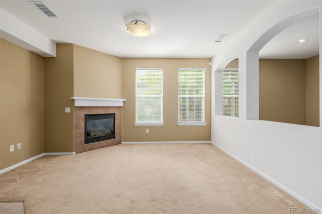 unfurnished living room with carpet floors, a fireplace, and visible vents