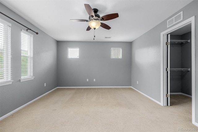 unfurnished bedroom featuring visible vents, a spacious closet, and multiple windows