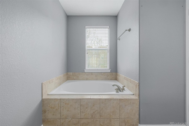 full bathroom with a garden tub and a textured wall