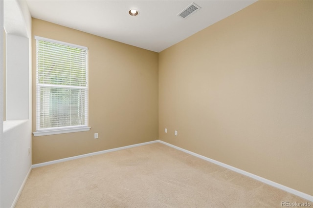 unfurnished room with light colored carpet, baseboards, plenty of natural light, and visible vents