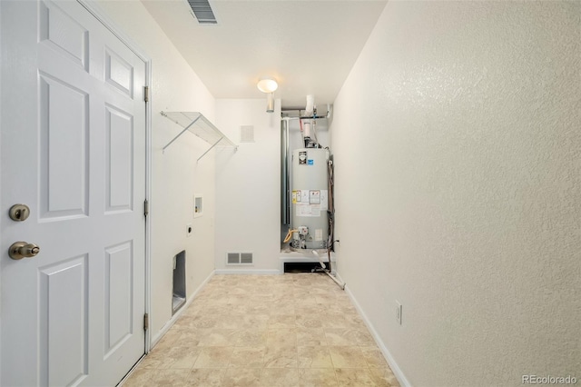 washroom with water heater, washer hookup, laundry area, and visible vents