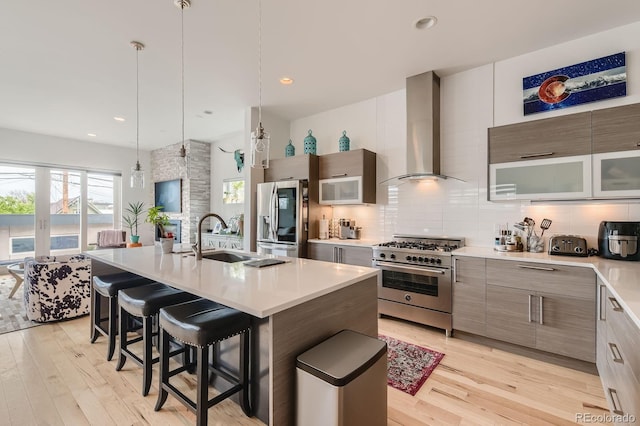 3632 N Pecos St, Denver, CO 80211 - kitchen with appliances with stainless steel finishes, wall chimney exhaust hood, a sink, a breakfast bar area, and modern cabinets