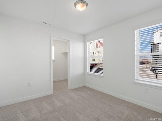 carpeted empty room with visible vents and baseboards