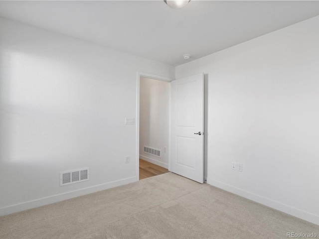 unfurnished room featuring carpet floors, baseboards, and visible vents