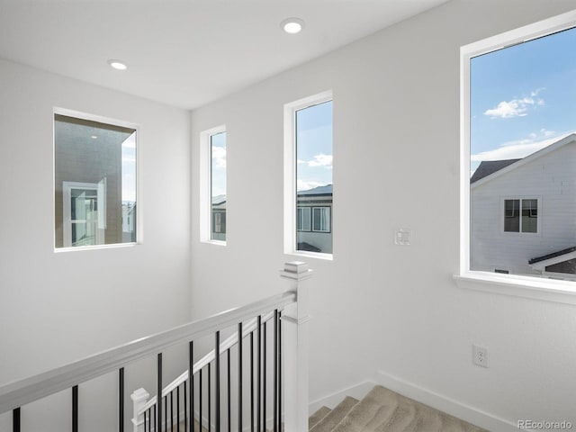 corridor featuring recessed lighting, stairway, and baseboards