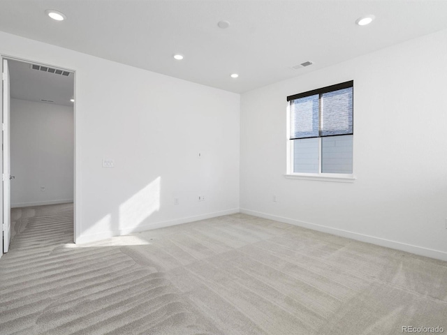 spare room with recessed lighting, visible vents, and light colored carpet