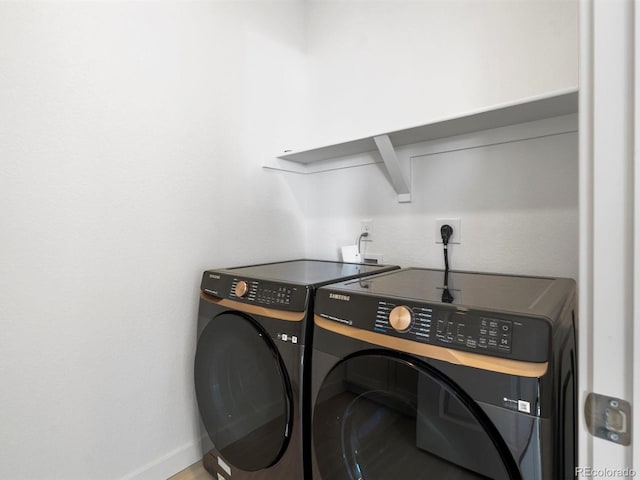 laundry room with laundry area, baseboards, and washer and clothes dryer