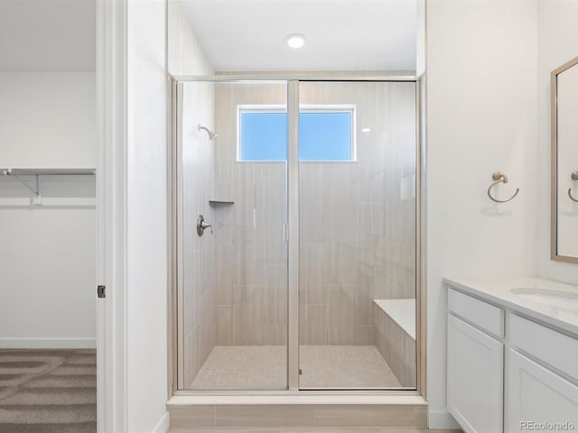 full bath featuring a spacious closet, a shower stall, and vanity