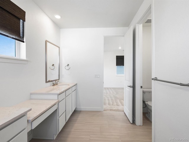 bathroom featuring visible vents, baseboards, vanity, and toilet