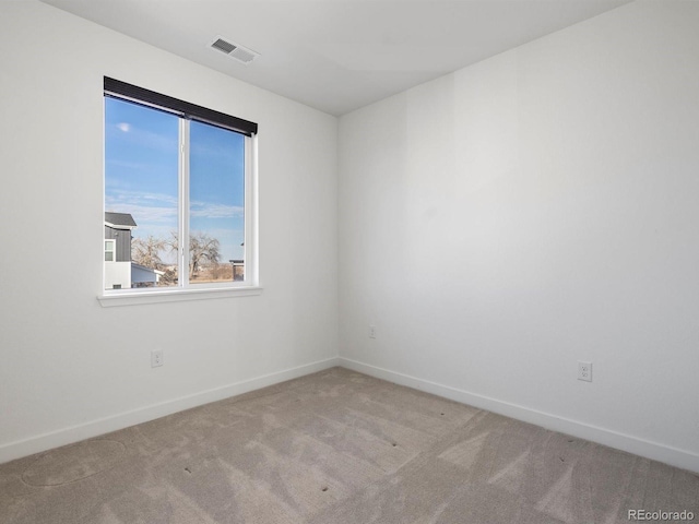 carpeted spare room with visible vents and baseboards