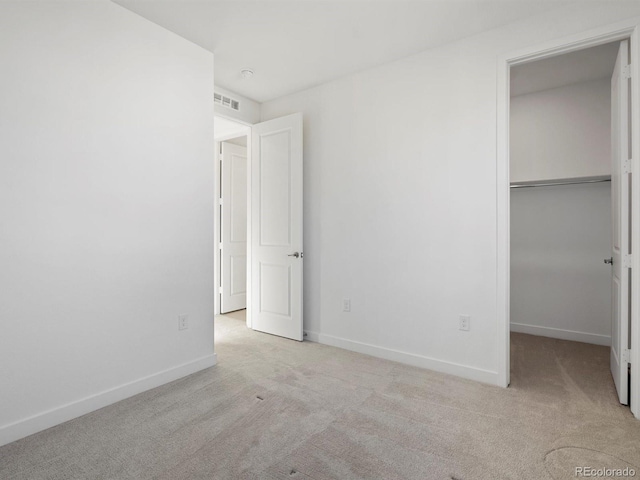 unfurnished bedroom with carpet floors, visible vents, baseboards, and a closet