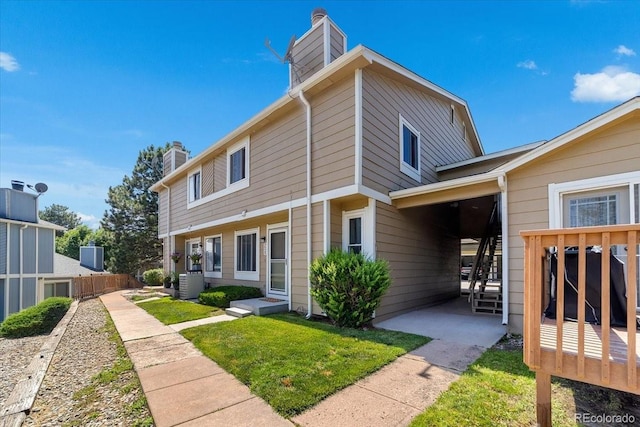 exterior space with central AC unit and a lawn