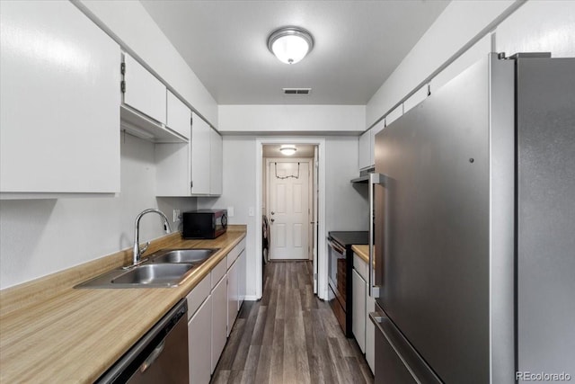 kitchen with sink, hardwood / wood-style floors, white cabinets, and appliances with stainless steel finishes