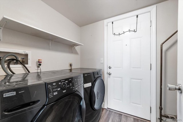 laundry area featuring dark wood-type flooring, hookup for a washing machine, washer and clothes dryer, and hookup for an electric dryer