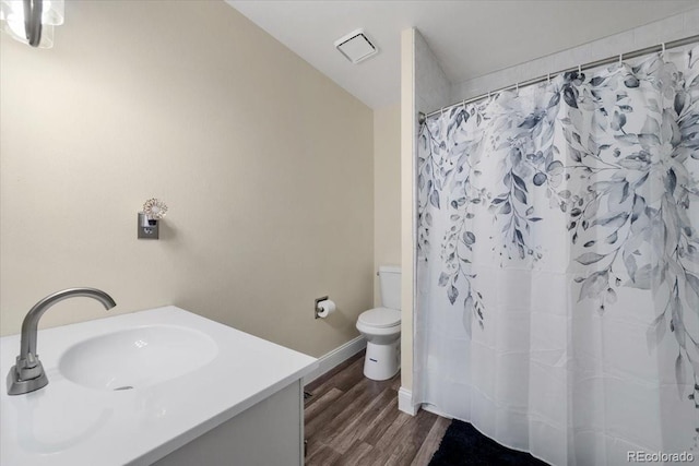 bathroom with wood-type flooring, vanity, and toilet