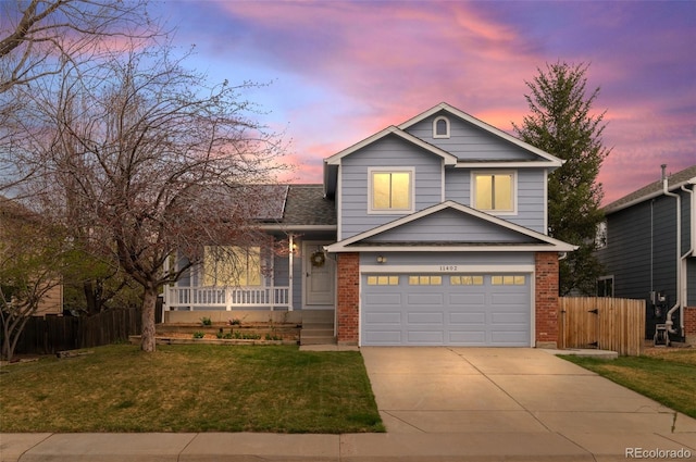 view of front of house featuring a yard, driveway, fence, and covered porch