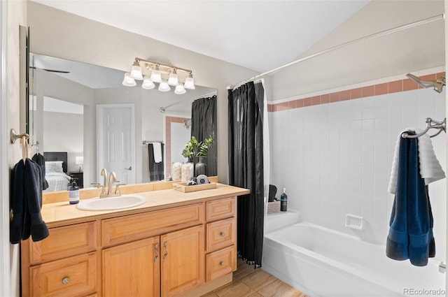 ensuite bathroom with ensuite bathroom, shower / tub combo with curtain, vanity, vaulted ceiling, and tile patterned floors
