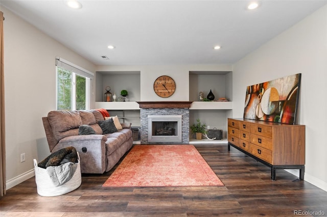 living area with baseboards, recessed lighting, a fireplace, dark wood finished floors, and built in shelves