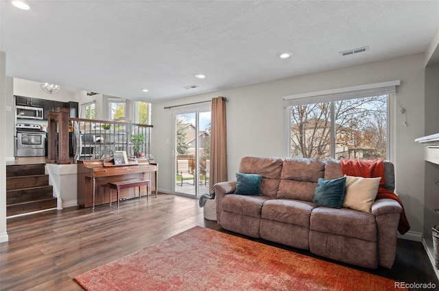 living room featuring visible vents, recessed lighting, a chandelier, wood finished floors, and baseboards