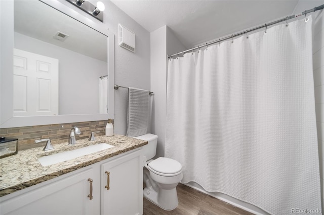 bathroom featuring decorative backsplash, hardwood / wood-style floors, toilet, vanity, and a shower with shower curtain