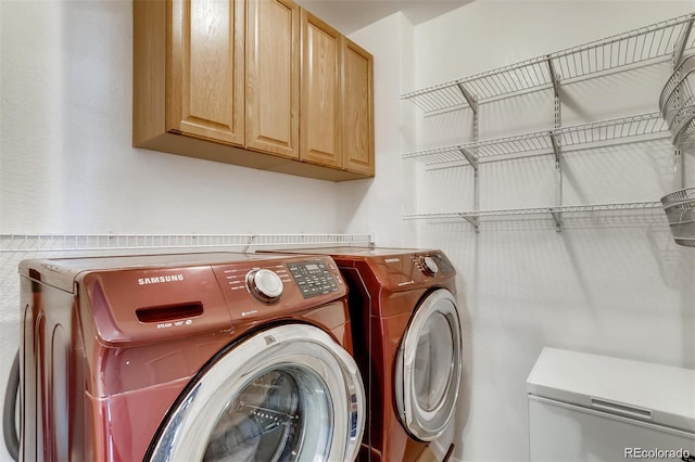 laundry room with washer and dryer and cabinets