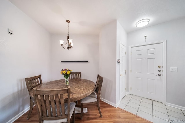 dining room featuring an inviting chandelier and light wood-type flooring