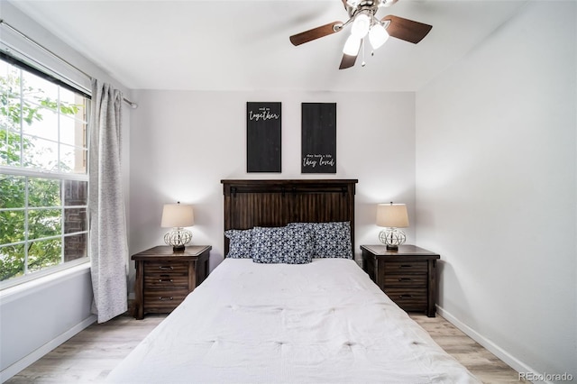 bedroom with light hardwood / wood-style flooring, multiple windows, and ceiling fan