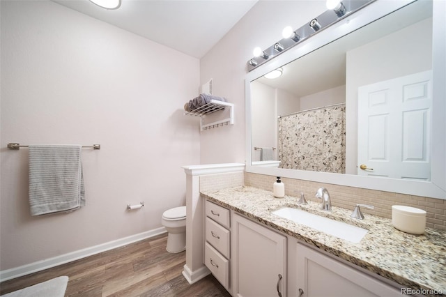 bathroom featuring vanity, toilet, tasteful backsplash, and hardwood / wood-style floors