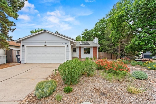 4194 S Kalispell St, Aurora, CO 80013 - ranch-style house featuring roof mounted solar panels, driveway, a chimney, an attached garage, and brick siding