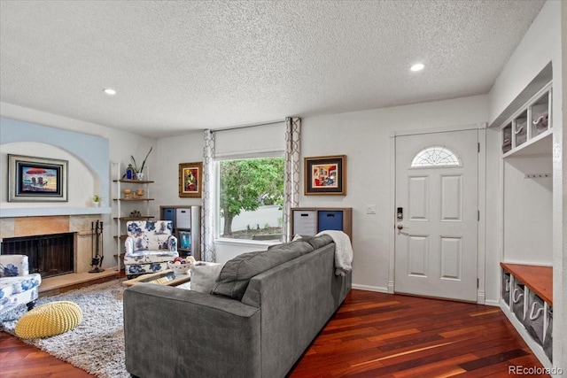 4194 S Kalispell St, Aurora, CO 80013 - living area featuring dark wood-style flooring, a textured ceiling, a fireplace, and recessed lighting