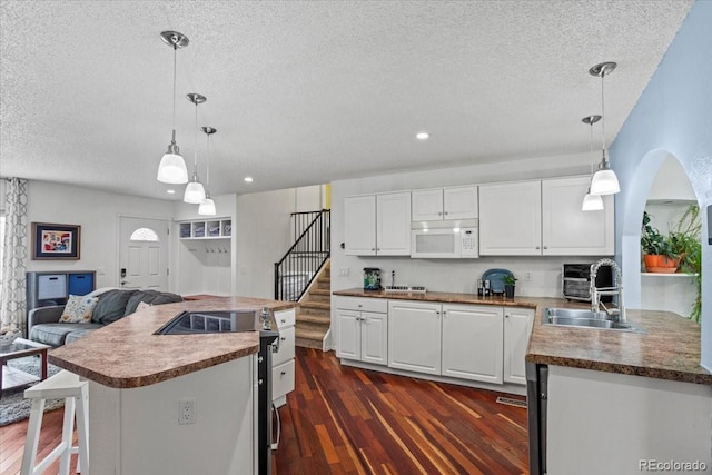 4194 S Kalispell St, Aurora, CO 80013 - kitchen featuring white microwave, a textured ceiling, white cabinetry, dark wood finished floors, and recessed lighting