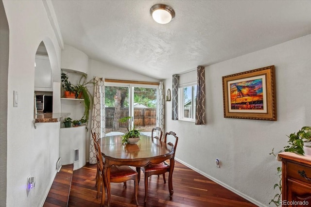 4194 S Kalispell St, Aurora, CO 80013 - dining area featuring lofted ceiling, dark wood-style floors, a textured ceiling, and arched walkways