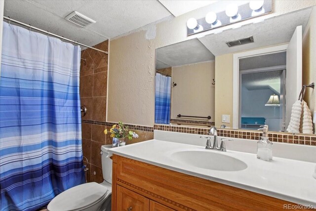 4194 S Kalispell St, Aurora, CO 80013 - bathroom featuring tile walls, vanity, a textured ceiling, a textured wall, and curtained shower
