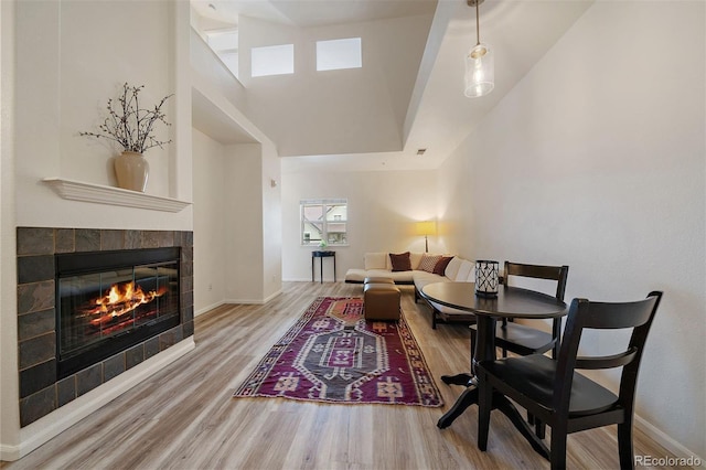 5465 Zephyr St Unit 201, Arvada, CO 80002 - living room with wood finished floors, a tiled fireplace, and a high ceiling