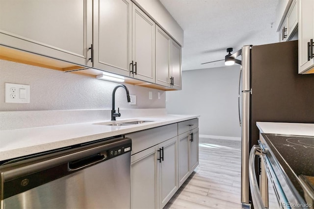 kitchen featuring gray cabinets, ceiling fan, light hardwood / wood-style flooring, sink, and stainless steel appliances