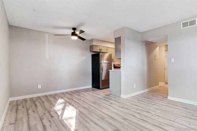 unfurnished living room featuring light wood-type flooring, ceiling fan, and a textured ceiling