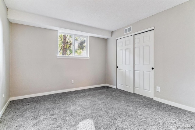 unfurnished bedroom with a closet, carpet, and a textured ceiling