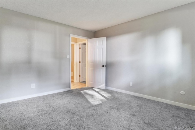 spare room with a textured ceiling and light colored carpet