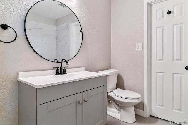 bathroom featuring tile patterned flooring, vanity, and toilet